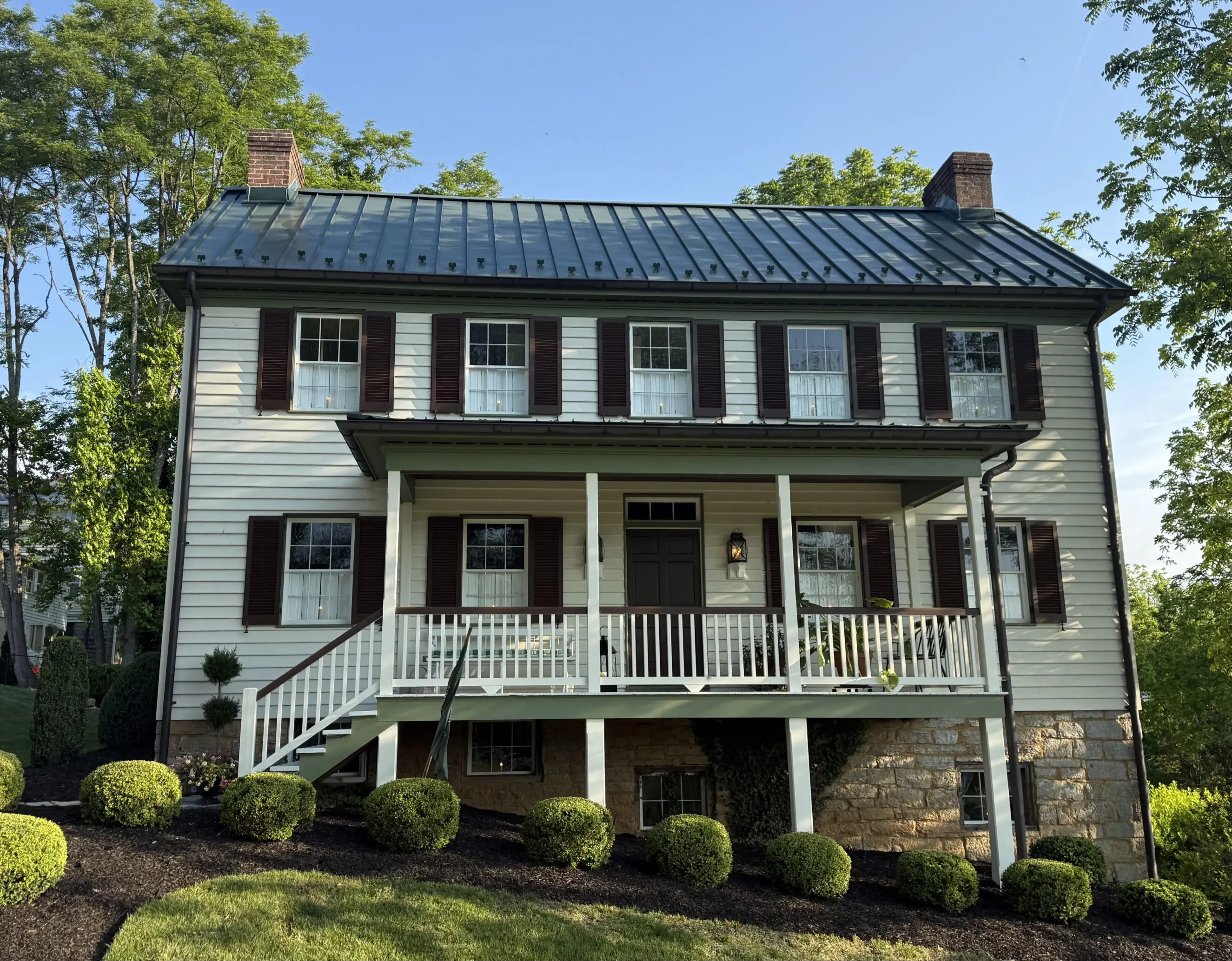 107 Park Street, Humphreys House Two-story white Humphreys House with green metal roof, brown shutters, porch, and