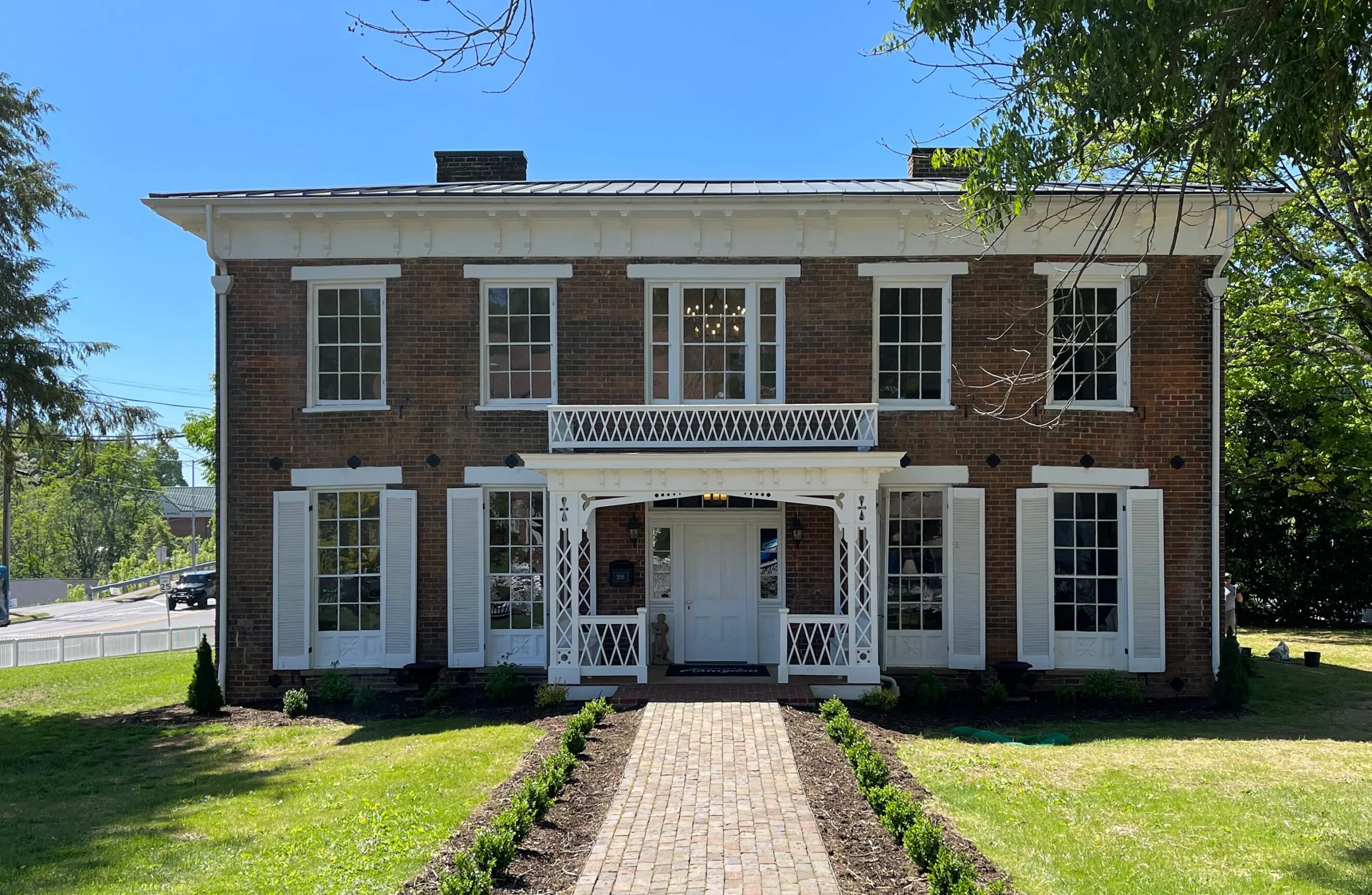 208 West Main St., Fields-Penn House (1) Historic two-story brick Fields-Penn House with white shutters and front porch in